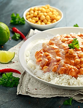 Spicy chickpeas curry with rice, tomato and Poppadoms in white plate. Healthy tasty vegetarian food