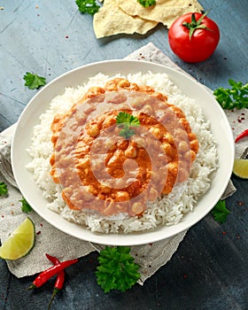 Spicy chickpeas curry with rice, tomato and Poppadoms in white plate. Healthy tasty vegetarian food