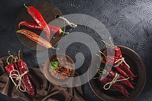 Spicy chili on a dark background in ceramic plates, flatlay