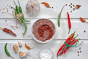 Spicy chili on a light background, flatlay. Used as an ingredient for harissa, ajika, muhammara. red hot chilli pepper, salt,