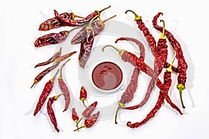 Spicy chili sauce in bowl isolated on white background. Different varieties of dry hot peppers, main ingredient for preparation.