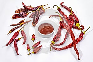 Spicy chili sauce in bowl isolated on white background. Different varieties of dry hot peppers, main ingredient for preparation.