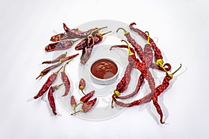 Spicy chili sauce in bowl isolated on white background. Different varieties of dry hot peppers, main ingredient for preparation.