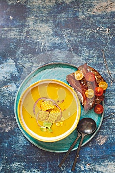 Spicy chilled corn and avocado soup served with bacon toast