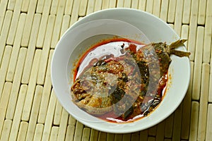 Spicy climbing gourami fish dried red curry paste with basil on bowl