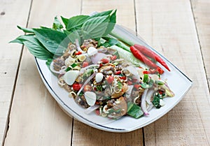 Spicy cockle salad on wooden background