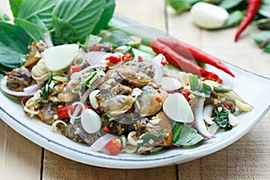 Spicy cockle salad on wooden background