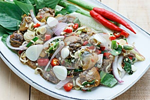 Spicy cockle salad on wooden background