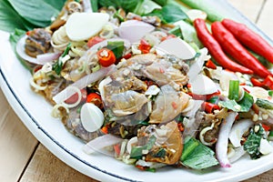 Spicy cockle salad on wooden background