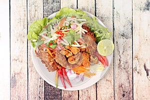 Spicy deep-fried chicken salad with roll green mango .