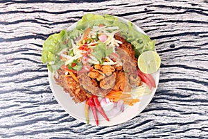 Spicy deep-fried chicken salad with roll green mango .