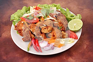 Spicy deep-fried chicken salad with roll green mango .