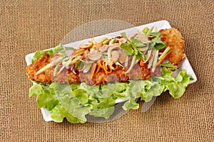 Spicy deep-fried Dolly`s fish salad with roll green mango.