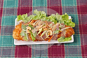 Spicy deep-fried Dolly`s fish salad with roll green mango.