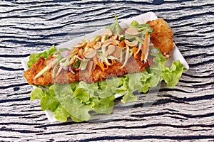 Spicy deep-fried Dolly`s fish salad with roll green mango.