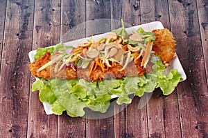 Spicy deep-fried Dolly`s fish salad with roll green mango.