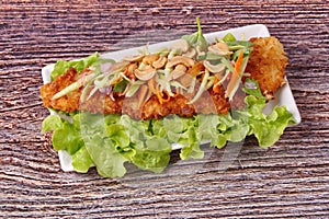 Spicy deep-fried Dolly`s fish salad with roll green mango.