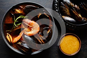 Spicy french soup bouillabaisse with seafood, prawns, mussels. Traditional in France, Spain. Dark rustic style.