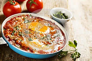 Spicy fried eggs with tomatoes and herbs