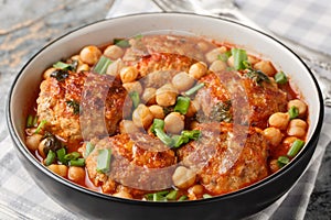 Spicy fried meatballs with chickpeas, tomato, mint and green onions close-up in a bowl. Horizontal