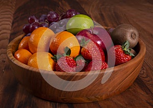 Spicy fruit salad on banana leaf in black dish on Rattan background.