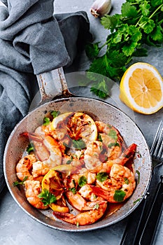 Spicy garlic chilli Shrimps on frying pan with lemon and cilantro