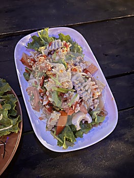 Spicy Glass Noodle Salad , Yum Woon Sen on wooden table , street Thai food.