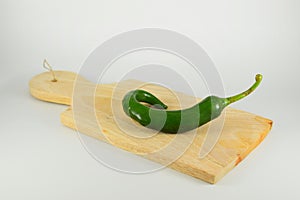 Spicy green chili on a wood cutting board