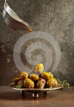 Spicy green olives are poured with olive oil with spices