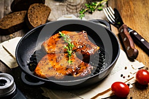 Spicy grilled pork chops in skillet