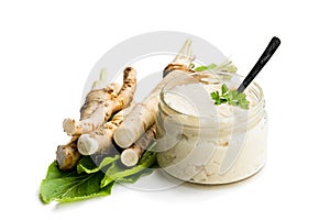 Spicy horseradish sauce in glass jar isolated on white