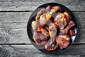 Spicy Jerk Chicken on a black plate photo