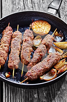 Spicy kefta kebab on skewers, vertical orientation