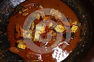 Spicy kerala style fish curry in clay pot.