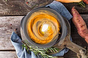 Spicy mashed sweet potato or sweet potato puree with rosemary in a saucepan on a table.  top view from above