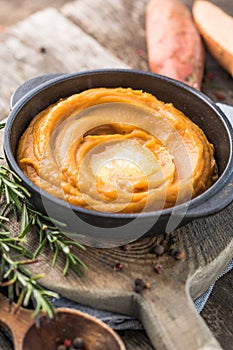 Spicy mashed sweet potato or sweet potato puree with rosemary in a saucepan on a table.  top view from above