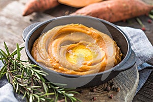 Spicy mashed sweet potato or sweet potato puree with rosemary in a saucepan on a table.  top view from above