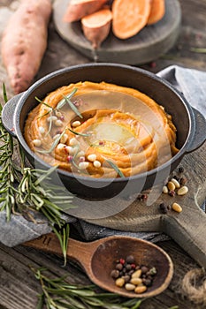 Spicy mashed sweet potato or sweet potato puree with rosemary in a saucepan on a table.  top view from above