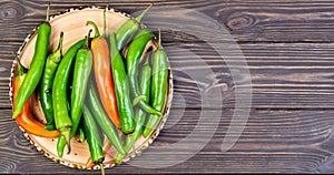 Spicy Mexican peppers on a platter. Spanish tapas on wooden vintage background. Flat top view with copy space, food still life