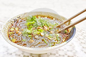 Spicy noodle soup with vegetables, herbs, peanuts and coriander.