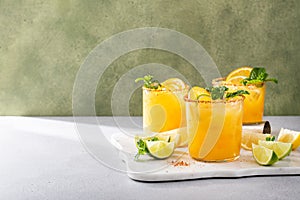 Spicy orange margarita with lime and orange slices garnished with mint