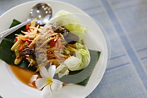 The Spicy papaya salad called `Somtum` in Thai on wooden table