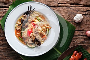 Spicy Papaya Salad with Salted Crab in White Dish, (Som Tam) on Banana Leaf