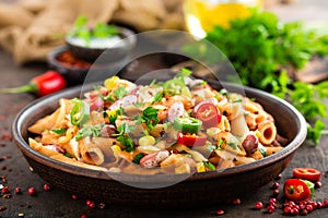 Spicy pasta penne bolognese with vegetables, beans, chili and cheese in tomato sauce