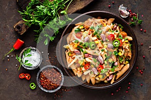 Spicy pasta penne bolognese with vegetables, beans, chili and cheese in tomato sauce