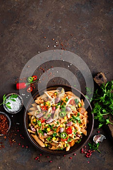 Spicy pasta penne bolognese with vegetables, beans, chili and cheese in tomato sauce