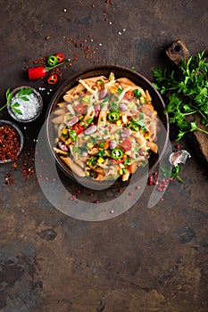 Spicy pasta penne bolognese with vegetables, beans, chili and cheese in tomato sauce