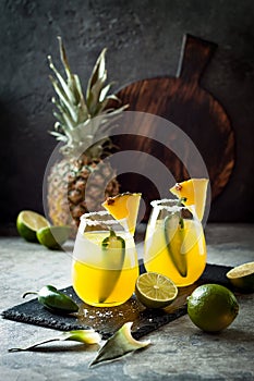 Spicy pineapple margarita cocktail with jalapeno and lime. Mexican alcoholic drink for Cinco de mayo party.