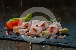 Spicy pork ham slices on black board