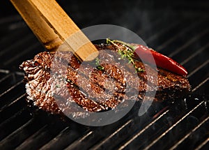 Spicy portion of seared steak grilling on a BBQ photo
